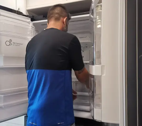 Refrigeração Experts - Assistência Especializada em Refrigeração no Rio de Janeiro Uma equipe de técnicos especializados em refrigeração da Refrigeração Experts trabalha em um conserto de geladeira.